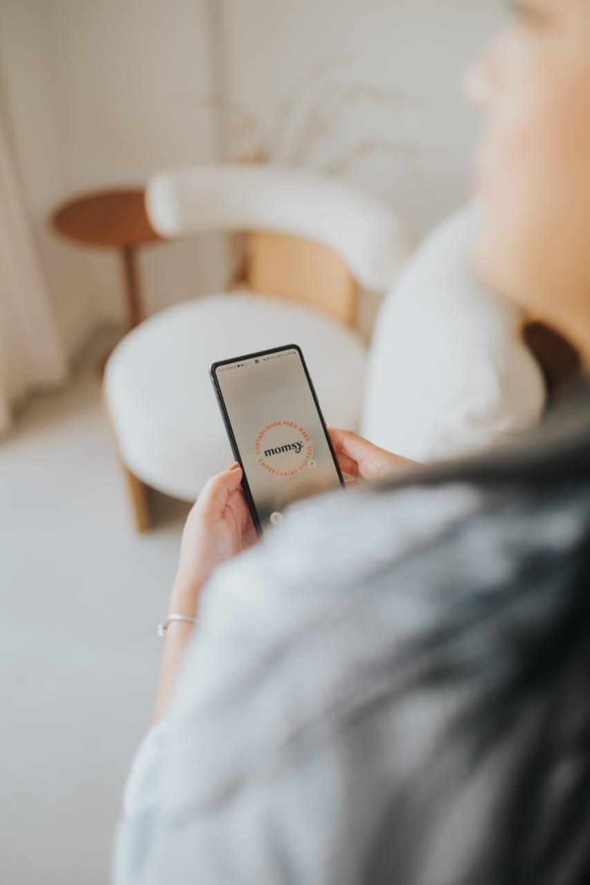 Celular exibindo a marca registrada da Momsy